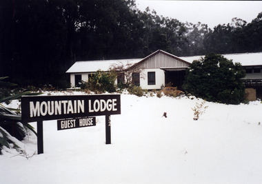 A digital copy of a black and white photograph of Mountain Lodge one winter.