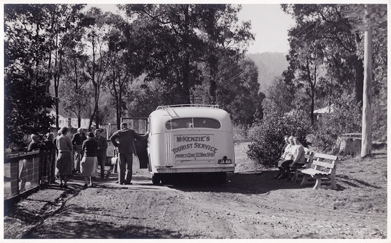 A black and white photograph of a McKenzie's Tourist Services bus taking guests from Roseleigh in Marysville on a day trip. The photograph was taken in April, 1949 by Roy Liebig.