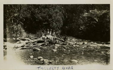 A black and white photograph of an unknown group of people at the Taggerty River in Marysville. The photograph was taken in 1954 whilst the group was staying at Roseleigh in Marysville.