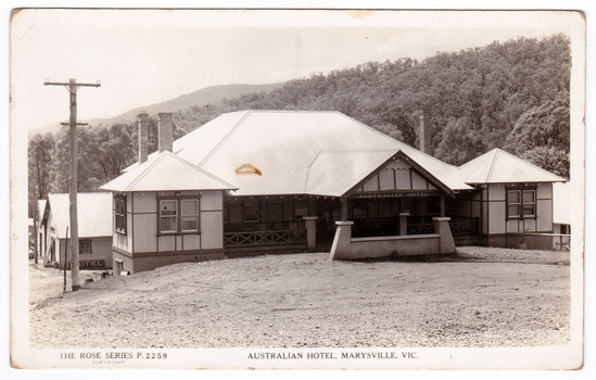 A black and white postcard from the Australian Hotel in Marysville that was produced by the Rose Stereograph Company as a souvenir of Marysville. The hotel was originally built and opened by the Keppel Family in 1865. The Keppel's Australian Hotel was the first hotel to be opened in Marysville. The Keppel Family were among Marysville's earliest pioneering families. On the reverse of the postcard is a space to write a message and an address and to place a postage stamp. The postcard is unused.
