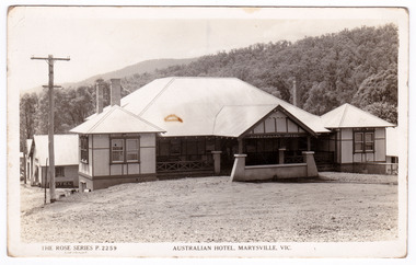A black and white postcard from the Australian Hotel in Marysville that was produced by the Rose Stereograph Company as a souvenir of Marysville. The hotel was originally built and opened by the Keppel Family in 1865. The Keppel's Australian Hotel was the first hotel to be opened in Marysville. The Keppel Family were among Marysville's earliest pioneering families. On the reverse of the postcard is a space to write a message and an address and to place a postage stamp. The postcard is unused.