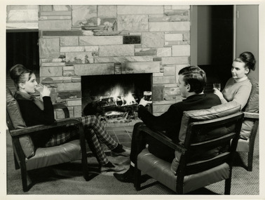 A black and white photograph of a group of three people enjoying a drink in the lounge at the Marysville Hotel Motel in Marysville. Two of the group are locals from Marysville and the photograph was possibly taken in the early 1960s.