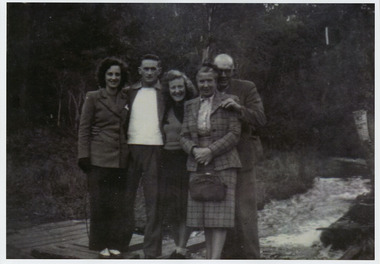 A copy of a black and white photograph of an unknown group of guests staying at Kooringa Guest House in Marysville standing by a river. The original photograph was taken in 1947.