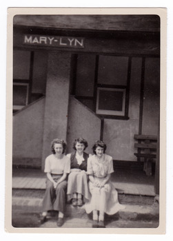 A black and white photograph of three ladies sitting on the front step at Mary-Lyn Guest House in Marysville. Mary-Lyn was a part of the Mary Chain of guest houses built by Eric Dowdle in the Depression years.