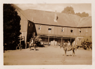 A black and white photograph of Mary-Lyn Guest House in Marysville. Mary-Lyn was part of the Mary Chain of guest houses built by Eric Dowdle in the Depression years. The photograph was taken in 1949 and is a view of the rear of the main building with two people on horse back out the front.