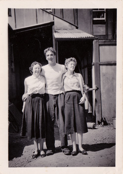 A black and white photograph taken at Mary-Lyn Guest House in Marysville. Mary-Lyn was a part of the Mary Chain of guest houses built by Eric Dowdle in the Depression years. The photograph is of two ladies and a young man standing outside the main building at Mary-Lyn.