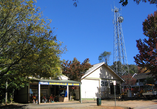 Shows the front facade of the Marysville Ski Centre in Victoria. Shows a building with advertising signs attached to the roof and verandah.