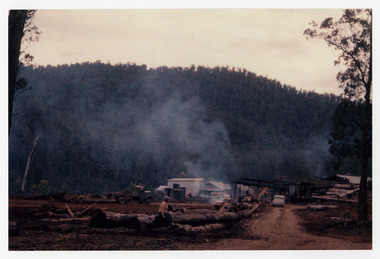 A copy of a colour photograph of the Cambarville timber mill in Victoria. Cambarville was established as a timber mill town in the 1940s. Timber mill owners A. Cameron and F.J. Barton named Cambarville. They established the mill to salvage timber from trees destroyed in the 1939 bushfires. Cambarville was impacted by the 2009 Black Saturday bushfires and any remaining structures were destroyed. The original photograph was taken in 1960.