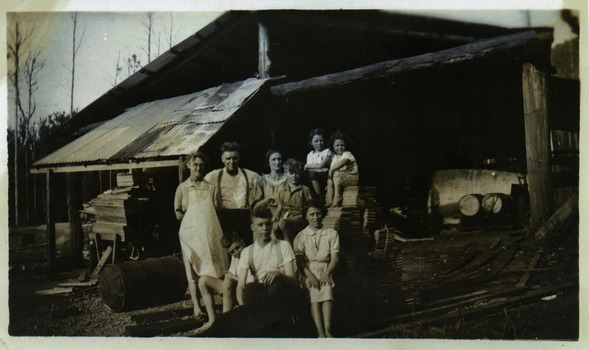 A copy of a black and white photograph of the Webb Family taken at the Andersons No. 1 Mill. George Webb worked at the mill. The original photograph was taken in the 1940s.