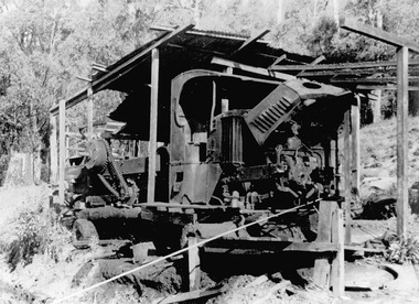 A copy of a black and white photograph of a Mack truck that was used to winch logs to the Andersons No. 2 mill.