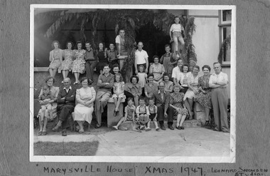 A digital copy of a black and white photograph of a group of people staying at Marysville House taken on Christmas Day in 1947. Marysville House was build in the late 1920s by Arthur Dickinson.