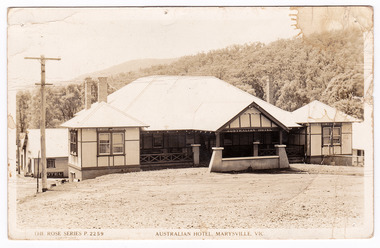 A black and white postcard from the Australian Hotel in Marysville that was produced by the Rose Stereograph Company as a souvenir of Marysville. The hotel was originally built and opened by the Keppel Family in 1865. The Keppel's Australian Hotel was the first hotel to be opened in Marysville. The Keppel Family were among Marysville's earliest pioneering families. On the reverse of the postcard is a space to write a message and an address and to place a postage stamp. The postcard is unused.
