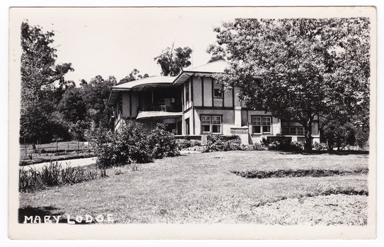 A black and white postcard from Mary Lodge Guest House in Marysville. The postcard was produced as a souvenir of Marysville. On the reverse is a space to write a message and an address and to place a postage stamp. The postcard is unused.