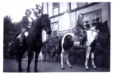 A black and white photograph taken at Mary Lodge Guest House in Marysville. The photograph was taken of two ladies horse riding out the front of Mary Lodge. The photograph was taken in April 1944.