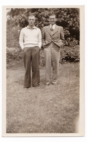 A black and white photograph taken in the garden at Mary Lodge Guest House in Marysville. The photograph is of two unknown men. The photograph was taken in 1941.