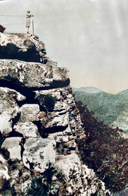 A digital copy of a colour photograph of Maria Chester standing on Mount Sugarloaf in the Cathedral Ranges in Victoria.