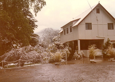 A copy of a sepia photograph taken at Kooringa Tourist House in Marysville. The photograph is of the main building and part of the garden after a light dusting of snow.