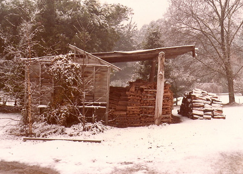 A digital copy of a sepia photograph taken at Kooringa Tourist House in Marysville. The photograph is of the firewood shed at Kooringa after a snowfall.