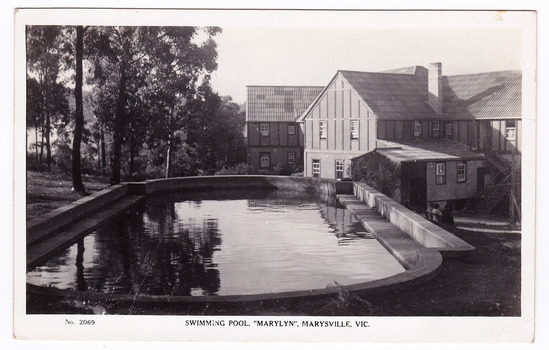 A black and white postcard from Marylyn Guest House in Marysville. Marylyn was a part of the Mary Chain of guest houses built by Eric Dowdle in the Depression years. The postcard was produced by the Rose Stereograph Company as a souvenir of Marysville. On the reverse of the postcard is a space to write a message and an address and to place a postage stamp. The postcard is unused.