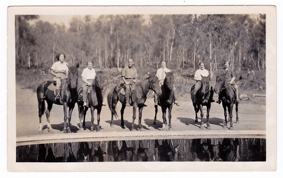 A black and white photograph taken at Mary-Lyn Guest House in Marysville. Mary-Lyn was part of the Mary Chain of guest houses built by Eric Dowdle in the Depression years. The photograph shows six riders on horseback standing near the swimming pool at Mary-Lyn.