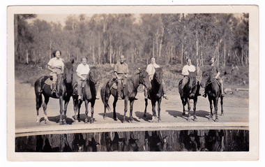 A black and white photograph taken at Mary-Lyn Guest House in Marysville. Mary-Lyn was part of the Mary Chain of guest houses built by Eric Dowdle in the Depression years. The photograph shows six riders on horseback standing near the swimming pool at Mary-Lyn.