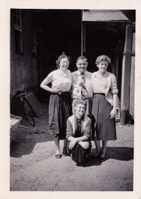 A black and white photograph taken at Mary-Lyn Guest House in Marysville. Mary-Lyn was a part of the Mary Chain of guest houses built by Eric Dowdle in the Depression years. The photograph is of Mr. Fred Fiske, the proprietor, and three women who may have worked at Mary-Lyn.