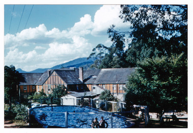 A copy of a colour photograph taken at Mary-Lyn Guest House in Marysville. Mary-Lyn was a part of the Mary Chain of guest houses built by Eric Dowdle in the Depression years. The photograph was taken in January 1961 and shows a view of the rear of the main building at Mary-Lyn as well as the swimming pool.