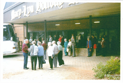 A colour photograph taken at Mary-Lyn Holiday Resort in Marysville. Mary-Lyn was a part of the Mary Chain of guest houses built by Eric Dowdle during the Depression years. The photograph shows several unknown people standing outside the front of the resort.