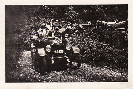 Two black and white photographs of cars travelling along the Black Spur in the 1920s.