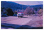 Two colour photographs of a McKenzie's bus travelling along the main street in Marysville. McKenzie's Tourist Services were associated with the growth of Marysville as a tourist destination.
