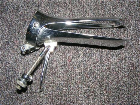 Two prong speculum with screws and spring.