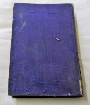 Blue paperboard cover with some tears, bubbling and stains