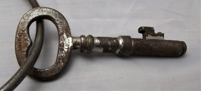 Metal key. Rust and scratches from wear and tear. 'J. Hubball' and 'Melbourne' engraved on bow.