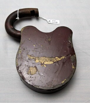 Brass padlock under brown paint with scraps and scratches 