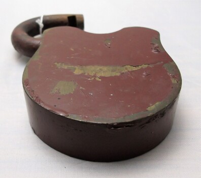 Brass padlock with brown paint, scrapes and scratches 