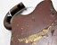 Brass padlock under brown paint with scraps and scratches 