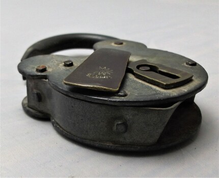 Side view of padlock with hinged keyhole cover