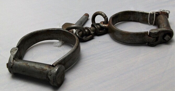 Side view of handcuffs with attached key