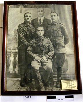 B & W photo showing 4 soldiers and a civilian