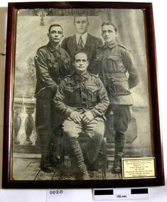 B & W photo showing 4 soldiers and a civilian
