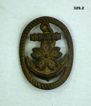 Brass badge with a flower and anchor