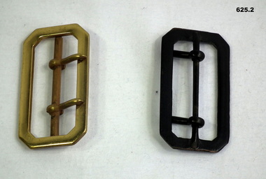 Two uniform belt buckles, one black one brass colour