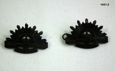 Two blackened Rising Sun lapel badges