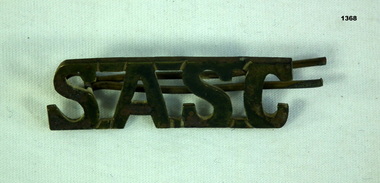 Brass badge with letters SASC 