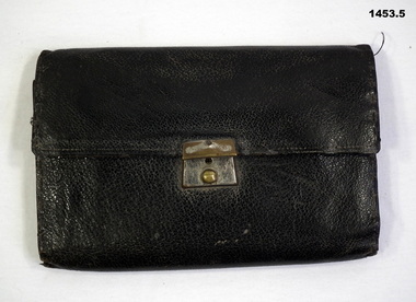 Black leather wallet with note book & articles.
