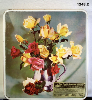 Biscuit tin with floral arrangement on lid