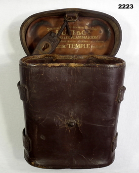 Brown leather binoculars case inscribed with initials.