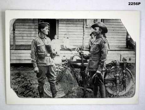 B & W photo showing two soldiers and and a motor bike.
