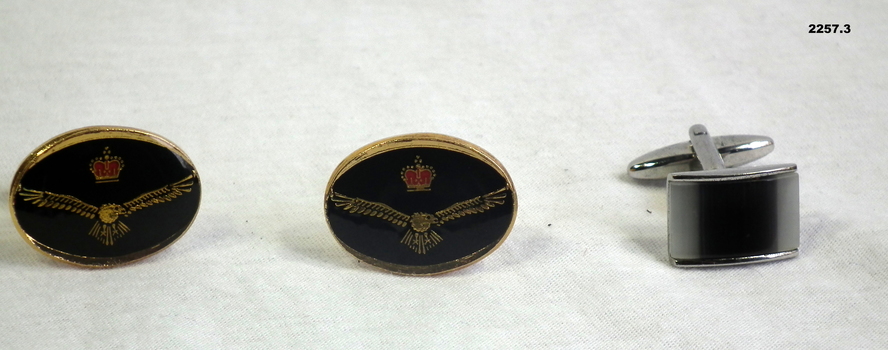 Three cuff links, two with wings on.