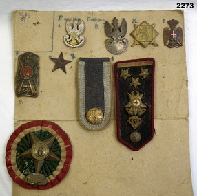 Series of badges mounted on cardboard.